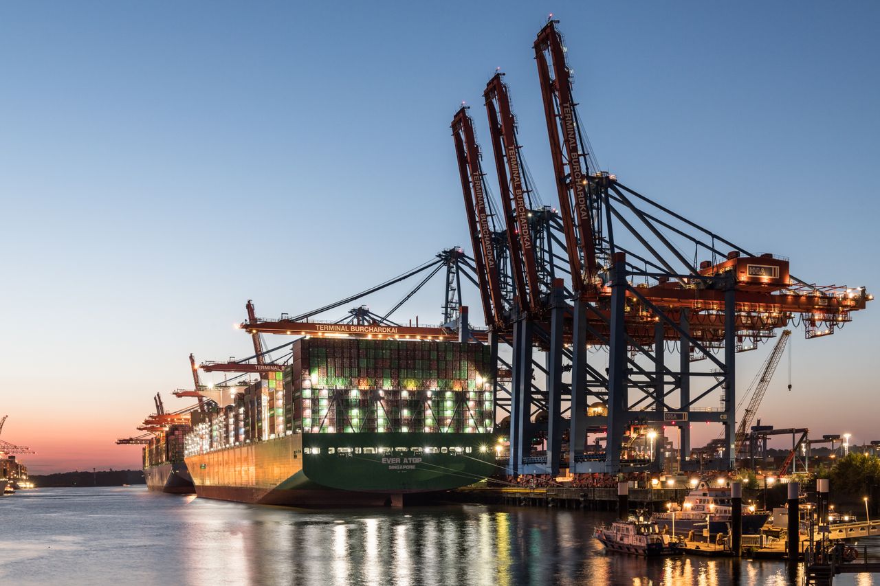 Services A large container ship at the Hamburg port with cranes during twilight, showcasing global trade.