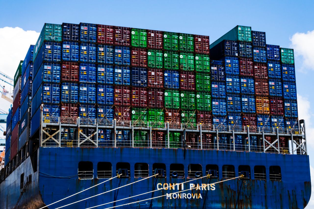Stacked cargo containers on a massive ship at the harbor, symbolizing global trade.